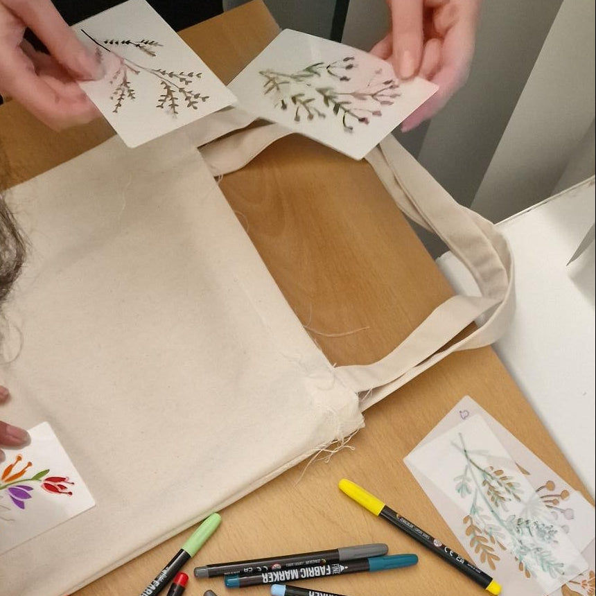 Person working on a craft project with stationery items on a table