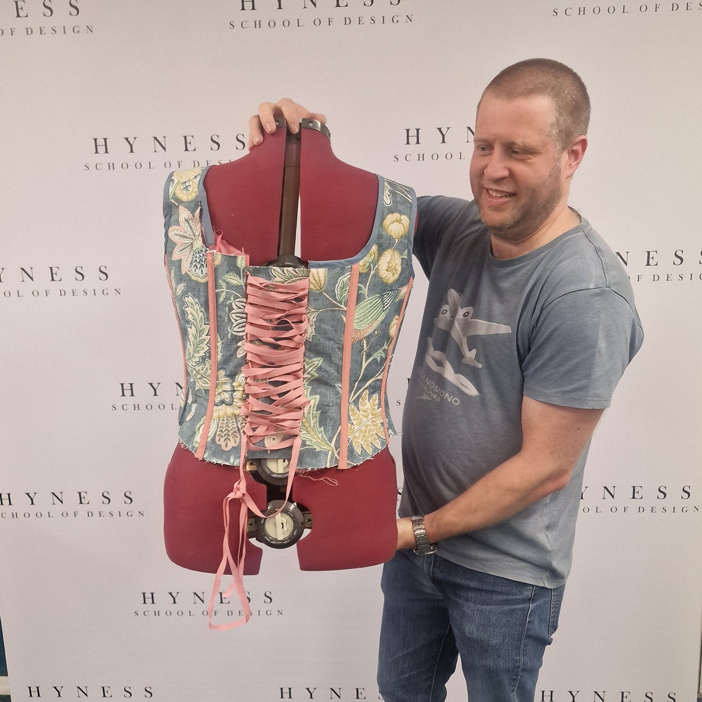 Person standing on a Hyness fashion display board with a mannequin