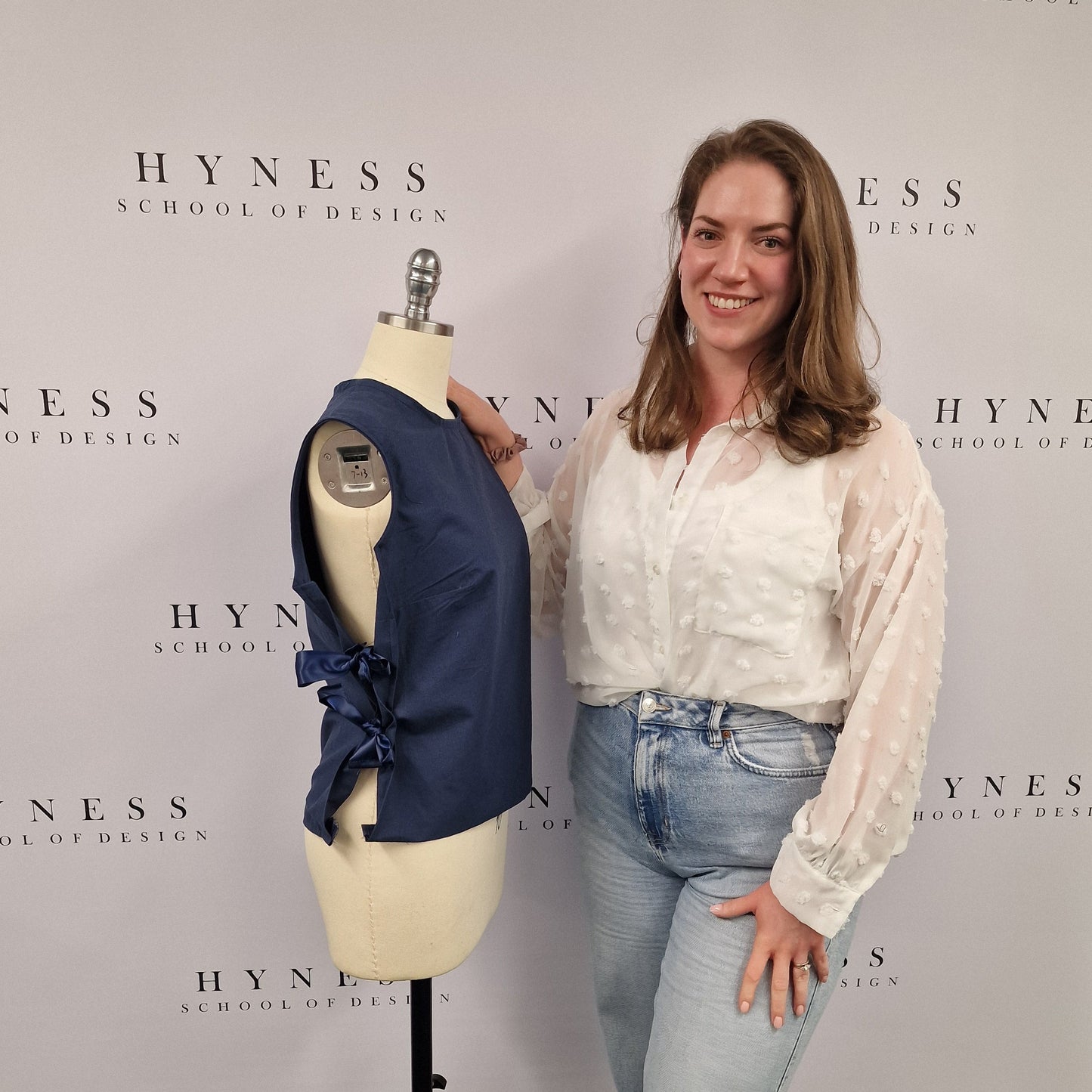 Person standing on a mannequin with a book titled 'Hynes' in the background