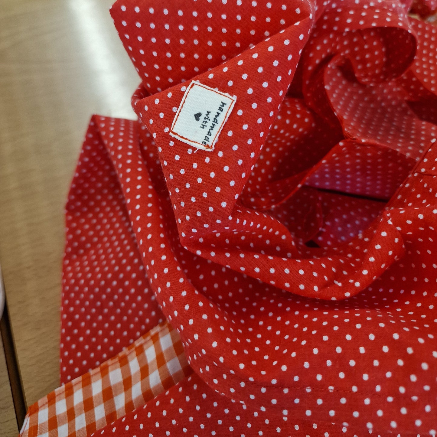 Red polka dot fabric with a visible brand label on a wooden surface