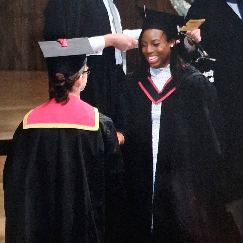 Graduates in academic dress on a red carpet with 'University of the Arts London' text.
