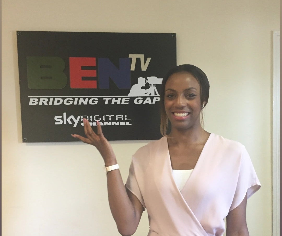 Woman standing in front of a screen displaying 'BEN TV' and 'sky digital plz'.